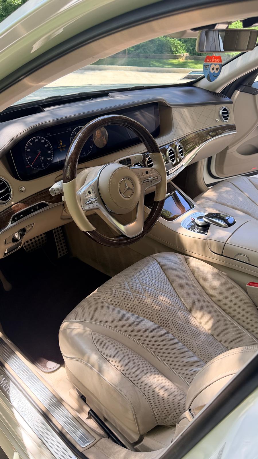 Interior car detailing in Riverside & San Diego County — luxury sedan cabin with cleaned cream leather seats, dashboard, and wood trim